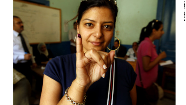 An Egyptian woman holds up an ink-stained finger after casting her vote at a polling station in Cairo.