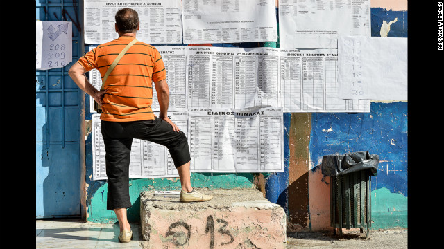 A man ponders the electoral board at a polling station in Athens before voting Sunday.