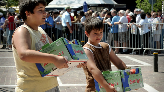 Children carry free vegetables donated by farmers from the Island of Crete in cooperation with the municipality of Athens, in Athens on June 20, 2012. The new coalition will have to deal with a devastating economic crisis. 