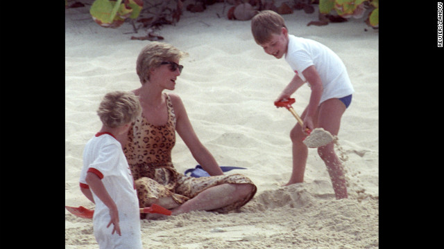 On a private beach in 1990, Prince William shovels sand onto his mother. Photos of the young prince with his adoring mother were common as media interest swelled.