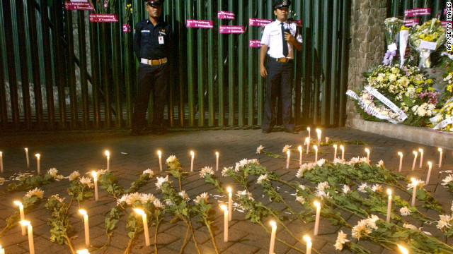 Two security guards stand in front of the Australian Embassy's front gate, where Indonesians placed candles and flowers to express their condolences for the victims of the Bali bombings.