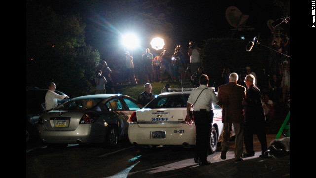 Sandusky is escorted in handuffs to a police car at the Centre County Courthouse under the glare of TV lights. The jury found Sandusky guilty on 45 of 48 counts.