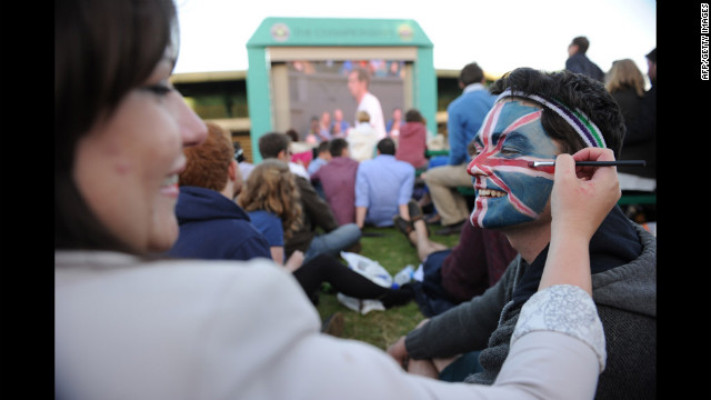 A spectator, Matt Griggs, right, has a Union Jack painted on his face by Kelsey Bennett, left, on 'Murray Mount' during the third-round men's singles match between Britain's Andy Murray and Cyprus' Marcos Baghdatis on Saturday.
