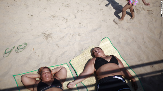 Beachgoers lie in the sun at Coney Island on Saturday.