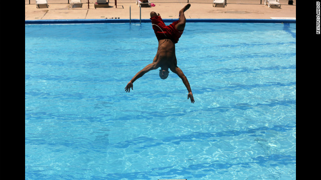 Lifeguard Niko Garcia jumps into a pool in Washington on Monday to try and beat the heat wave gripping the nation.