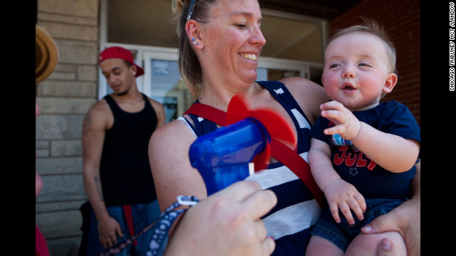 Lori Bryant holds her 7-month-old nephew Justin Tackett as Marianne Oliver cools him down during the Fourth of July parade in Downers Grove, Illinois.