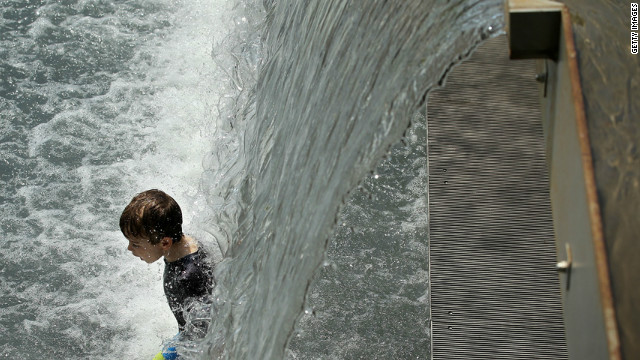 A boy enjoys the waterfall in the Yards Park fountain on Thursday.