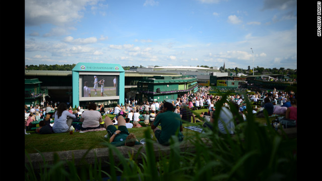 Spectators follow the day's matches on the big screen in the afternoon sun on Murray Mound on Thursday.