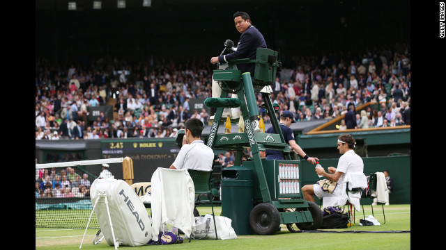 Umpire James Keothavong looks on as Novak Djokovic of Serbia and Roger Federer of Switzerland take a break during their Gentlemen's Singles semifinal match on Friday, July 6, in London, day 11 of the tournament. 