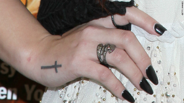 Singer/actress Demi Lovato, 19, displays a tattoo of a cross during a book signing.