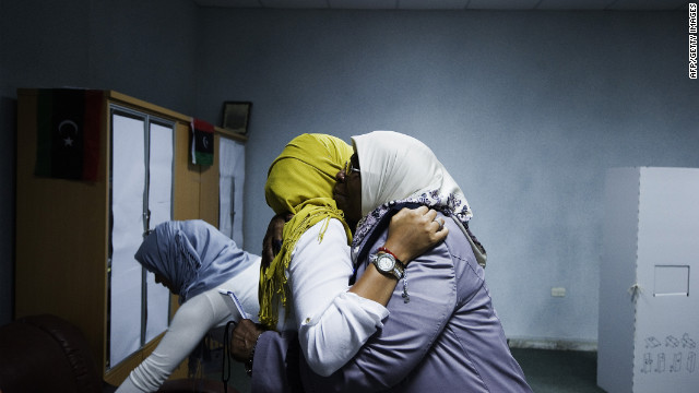 Two Libyan election workers embrace after voting ends at a Tripoli polling station.