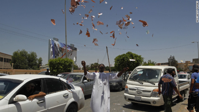 A Libyan protester throws torn ballots in the air outside a Benghazi polling station.