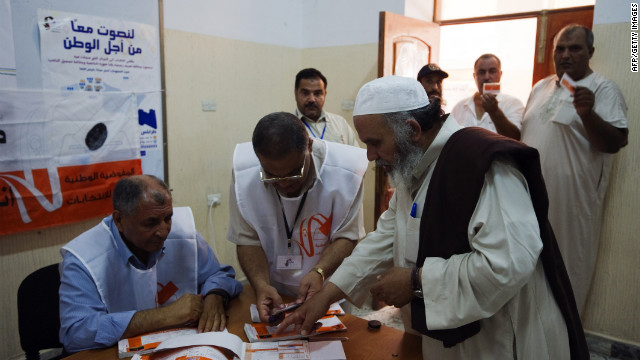 Libyan election workers check the identification card of a voter at a Tripoli polling station.