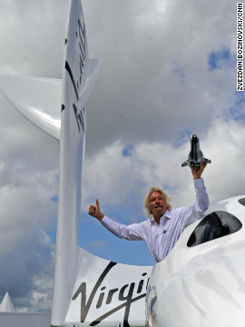 Richard Branson hangs out of the window of SpaceShipTwo, currently on display for the first time in Europe at the Farnborough Airshow, with a model of LauncherOne. According to Branson, the maiden voyage for LauncherOne is expected to be 2015.