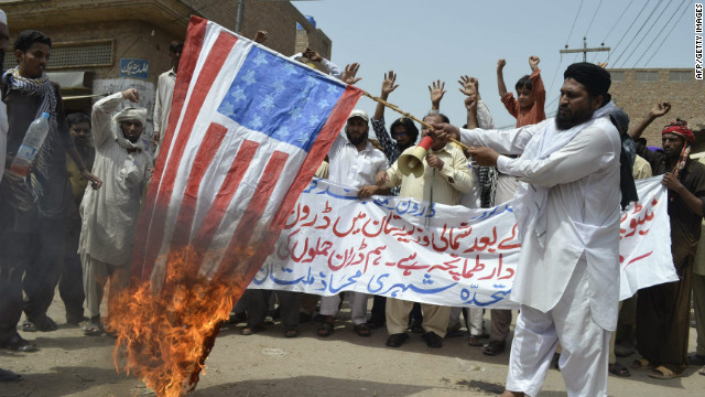 A man burns the U.S. flag in protest of a drone strike in Multan, Pakistan, on July 7.