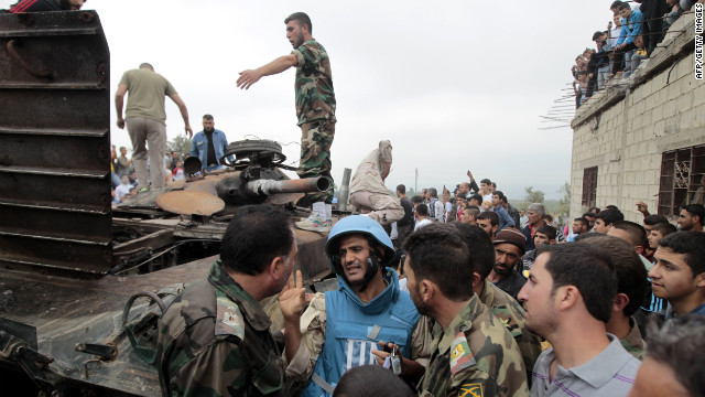 A U.N. observer speaks with Syrian rebels and civilians in the village of Azzara on May 4, 2012, days before the country's parlianemtary polls were held against a backdrop of unrest.