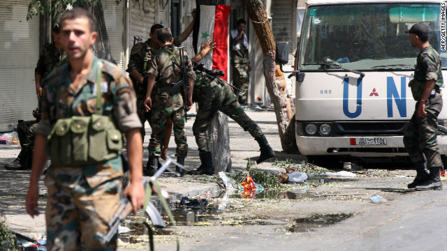 Syrian army soldiers hang their national flag in a partially destroyed neighborhood in the al-Midan area in Damascus.