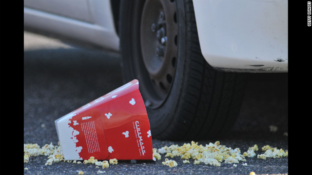 A popcorn box lies on the ground outside the Century 16 movie theatre.