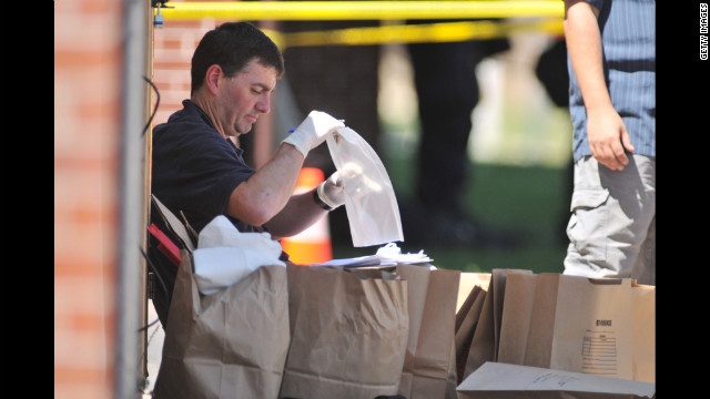 Investigators work on evidence near the apartment of James Holmes on Friday.
