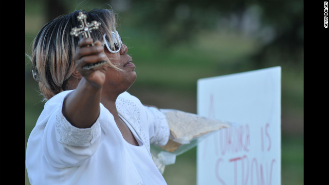 Marietta Perkins of Denver prays for victims and their families.