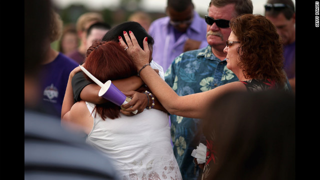 Movie theater shooting victim A.J. Boik's girlfriend, Lasamoa Croft, center, embraces his mother during the memorial service.