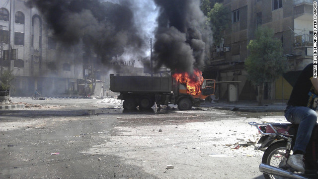 In this photo released by the Shaam News Network, a truck burns after shelling in the Erbeen suburb of Damascus on Saturday, July 21.