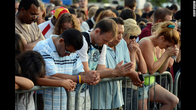 Mourners bow their heads in prayer during the vigil for the victims of the Aurora shooting.