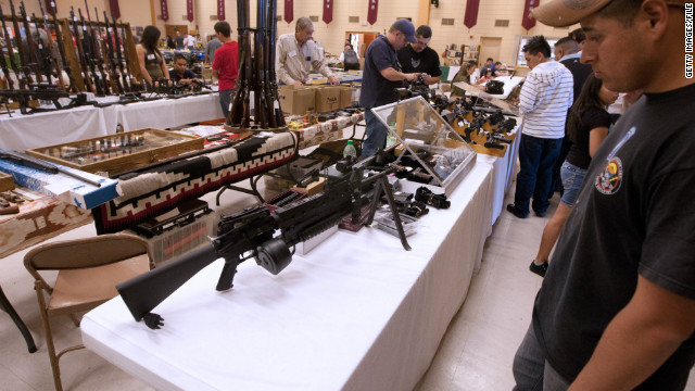 An assault rifle is equipped with a high-capacity drum magazine and grenade launcher at an El Paso, Texas, gun expo.