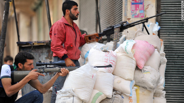 Syrian rebels take cover behind sandbags during fighting Monday at the entrance to the city of Selehattin.