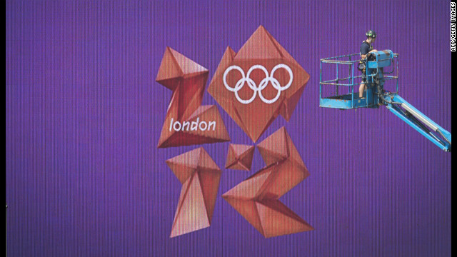 The London Olympics logo in the equestrian arena in Greenwich, London, is seen behind a worker on a lift.