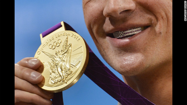 Lochte poses with medal on Saturday. His dental braces bear the U.S. flag.