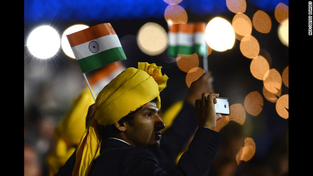 A member of India's delegation takes a picture as he parades during the opening ceremony.
