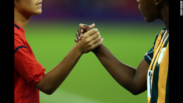 Japan and South African players shake hands before their women's football first-round match Tuesday.