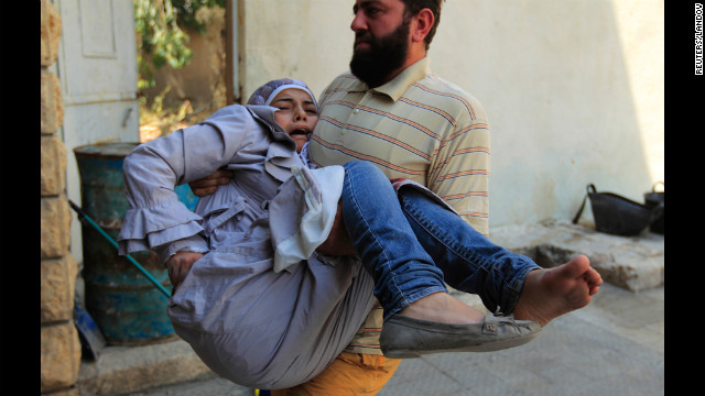 A member of the Free Syrian Army carries an injured civilian to safety in Aleppo's district of Salah Edinne on Tuesday.