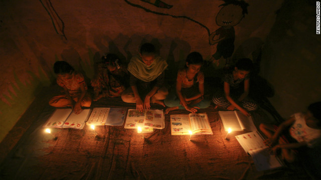 Girls study by candlelight at a school in Noida on the outskirts of New Delhi during a power failure Monday, July 30.