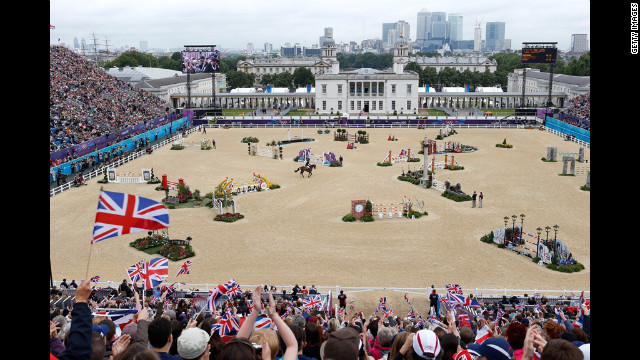 Fans wave Union Jack flags as Britain's William Fox-Pitt, riding Lionheart, performs Tuesday in the show-jumping qualifying equestrian event at Greenwich Park.