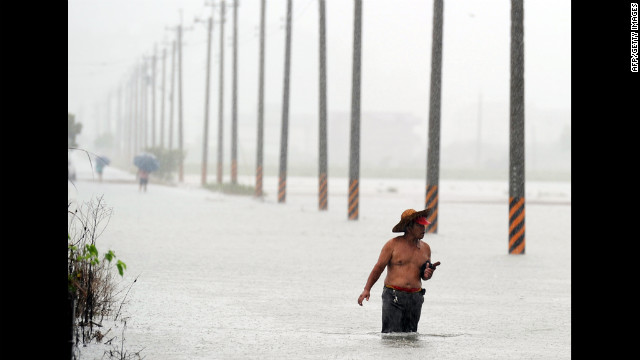 Taiwan residents wade in floodwaters in Wuche, in eastern Ilan County, as typhoon Saola approches the island's east coast on Thursday, August 2. The typhoon dropped as much as 1.5 feet of rain in parts of the Philippines before making landfall in Taiwan on Thursday.