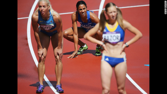Italy's Libania Grenot, center, checks out the scoreboard after the women's 400-meter heats.