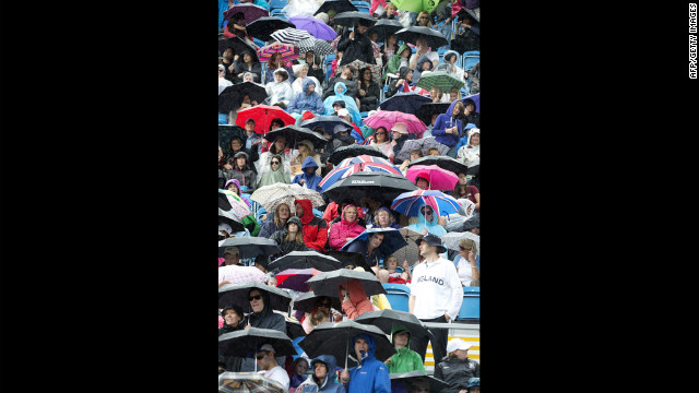 Spectators take cover during the dressage preliminaries at Greenwich Park in London.