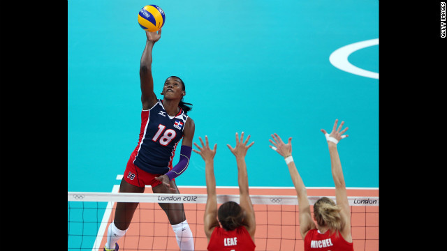 Bethania de la Cruz de Pena, left, of the Dominican Republic spikes the ball as Britain's Savanah Leaf, center, and Ciara Michel defend during women's volleyball action.