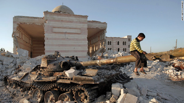 A boy plays on the gun of a destroyed Syrian army tank partially covered in the rubble of the destroyed Azaz mosques, north of the restive city of Aleppo, on Thursday, August 2.