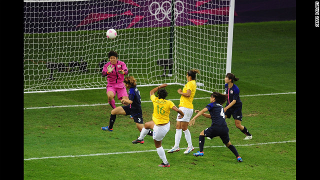 Renata Costa of Brazil blasts a shot over the bar as goalkeeper Miho Fukumoto of Japan looks on during the women's football quarter final match between Brazil and Japan on Friday.