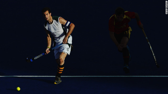 South Africa's captain Austin Smith, left, advances the ball forward with Roc Oliva of Spain in pursuit during the men's hockey match.