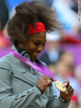 Williams admires her gold medal during the medal ceremony after defeating Sharapova in the women's singles match.