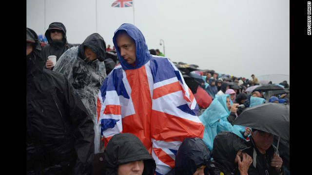 Spectators watch a rowing event as rain falls over Eton Dorney Rowing Centre west of London.