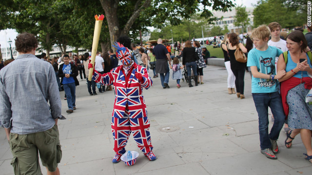 A performer dressed in a Union Flag suit and holding a mock Olympic flame entertains crowds on the South Bank in London.