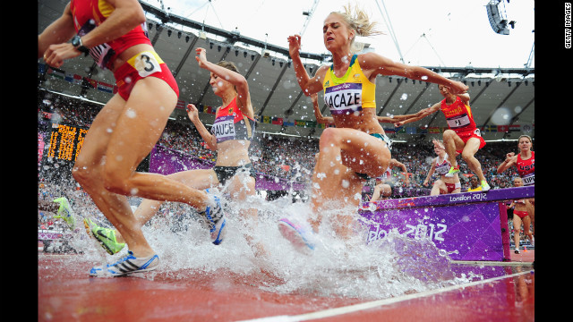 Runners compete in a women's 3000-meter steeplechase heat at Olympic Stadium.