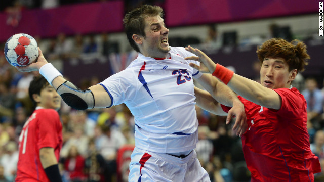 Serbia's left back Momir Rnic, left, jumps to shoot during a men's preliminary handball match against South Korea.