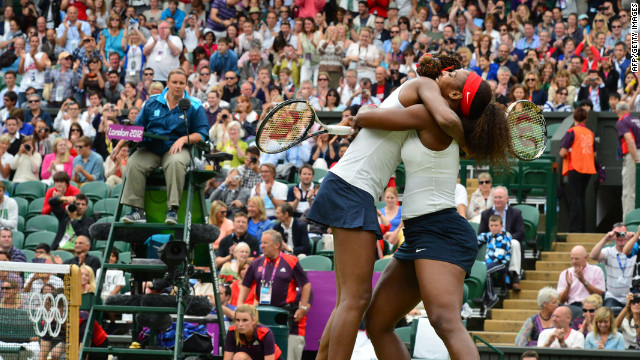 Venus Williams, left, and Serena Williams embrace after winning the women's doubles gold medal match on Sunday.