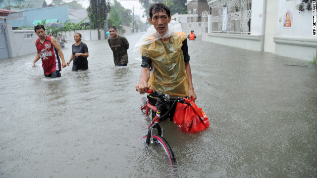 A resident pushes his bicycle through floodwaters in Quezon City in suburban Manila.
